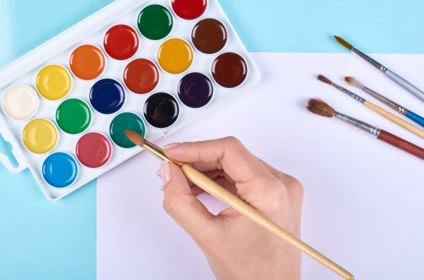 istock Watercolor paint and brushes on blue background. 1223358975