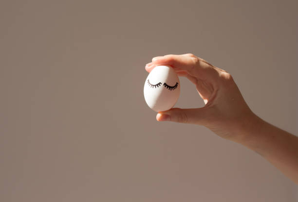 white egg mock-up in a girl's hand under a beautiful shadow. minimal concept - white meat flash imagens e fotografias de stock