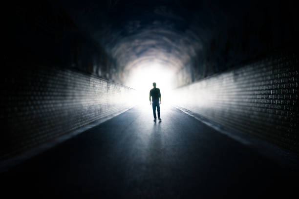 istock Man walking in dark tunnel 1223361148