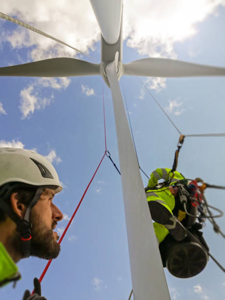 istock View from under on two rope access technicians working on blade of wind turbine high up 1223361441