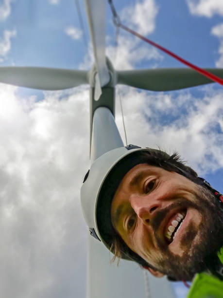 istock Charismatic Rope access technicians with beard and helmet took selfie under wind-turbine with blade and is excited! 1223361459