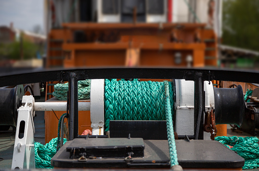 View of group of wooden pulleys and ropes in a sailboat.