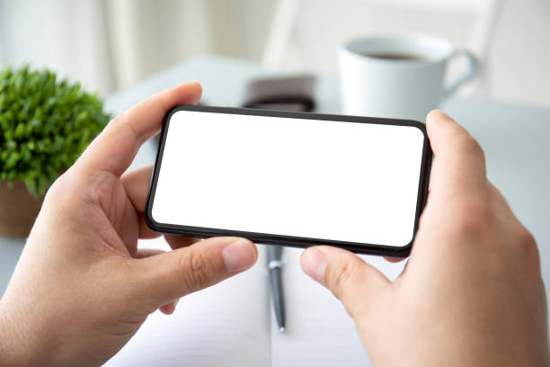 istock male hands holding horizontally phone with isolated screen in office 1223362361