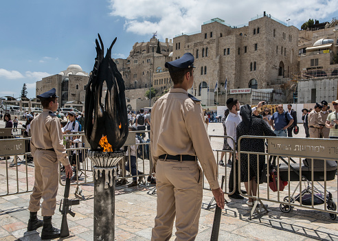 Jerusalem, Israel, May 8, 2019: Israel soldiers standing at attention by half-mast lowering Israeli flag, remembering to Israel's military heroes on Israel's Memorial Day, at Wailing Wall in Jerusalem Old City, Israel