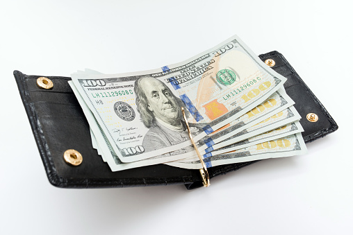 open black wallet with dollars lies on a white background