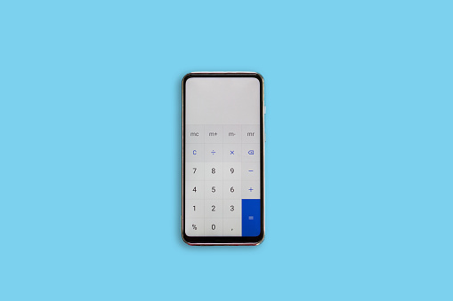 Calculator on the phone on blue background. Calculator.
