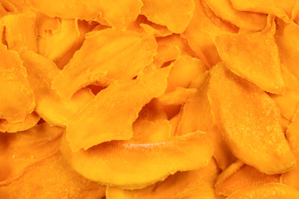 istock Tasty sugar mango slices background. Top view. 1223366629