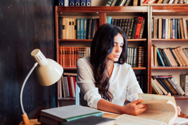 istock girl is preparing for the exam reading book at the library 1223367742