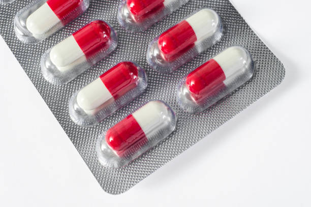 red white pills fall on a blue plate - narcotic medicine pill insomnia imagens e fotografias de stock