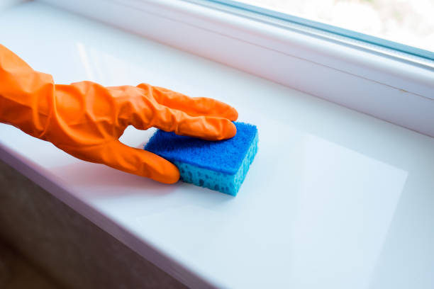 istock Hand in a glove sponges a plastic window sill 1223369152