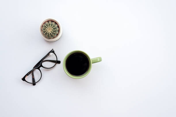 istock Office white  desk with a glasses, cup of coffee and cactus 1223371795