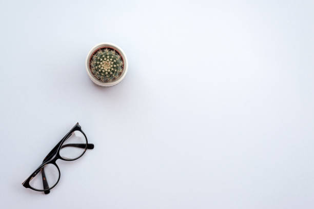 istock Top view office white desk with a glasses and cactus. 1223371873