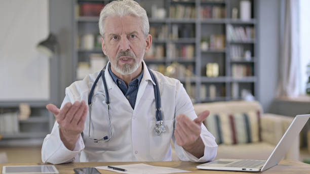 istock Senior Old Doctor doing Consultation with Patient, Video Chat 1223373819
