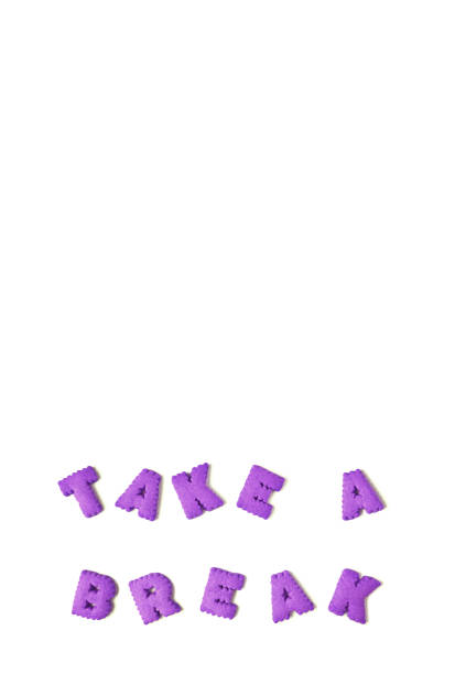 istock Vertical image of text TAKE A BREAK made with vivid violet alphabet shaped cookies on white background 1223373820