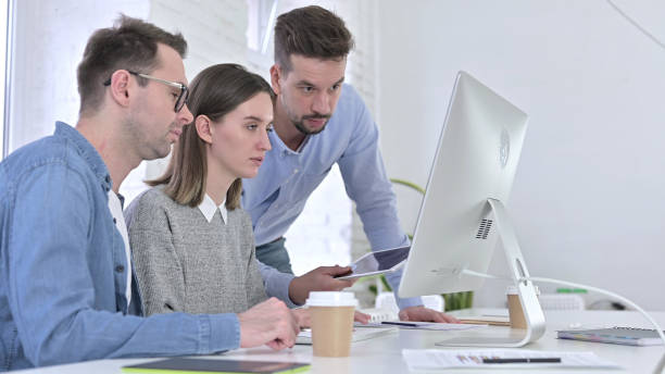 istock Attractive Team of Creative Professionals Working on Desktop Together 1223374084