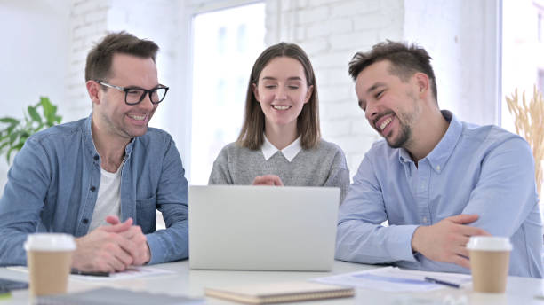 istock Cheerful Creative Team doing Video Chat on Laptop 1223375134