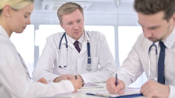 istock Young Doctors taking Notes and Listening to Senior Doctor 1223376872