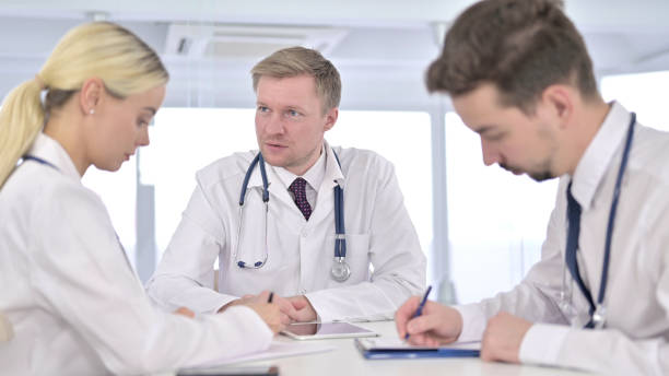 istock Doctors Writing while Listening to Senior Doctor 1223376891