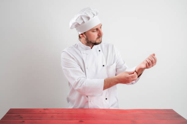 istock Young male chef in white uniform arranges his uniform 1223376937