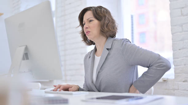 istock Creative Old Woman having Back Pain in Office 1223377310