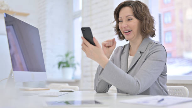 istock Creative Old Woman celebrating Success on Smartphone 1223377375