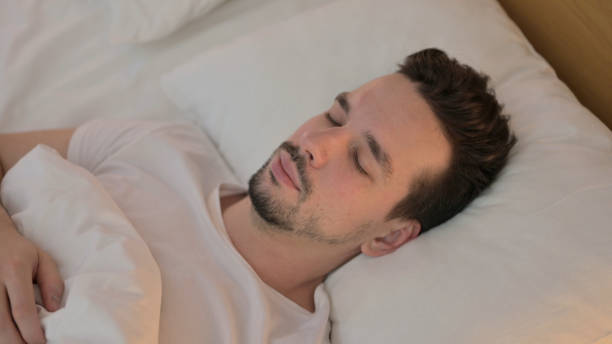 istock Portrait of Young Man Sleeping in Bed 1223377407