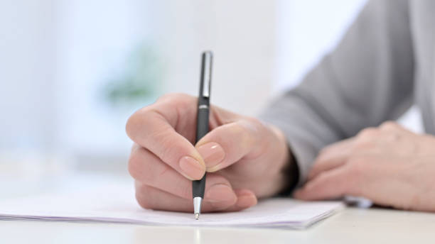 istock Close Up of Woman Hands Writing Documents 1223377683