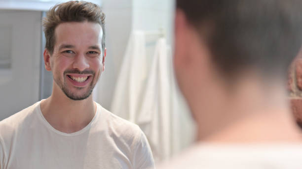 istock Young Man Smiling at Camera In Mirror 1223377698