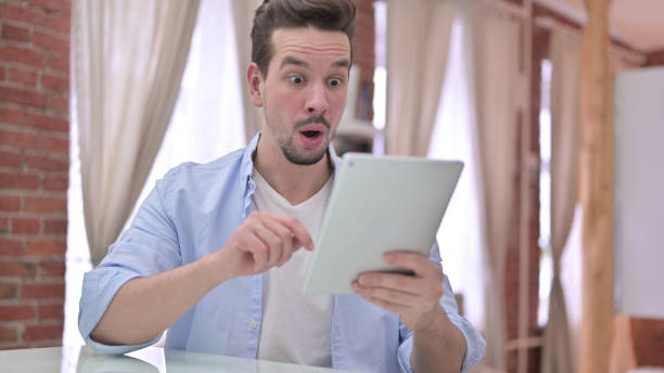 istock Upset Young Man get Shocked on Tablet 1223377888