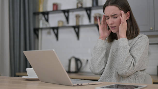 istock Young Woman having Headache and Working on Laptop 1223378669