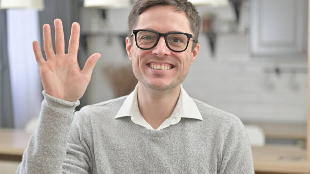 istock Young Man Waving at the Camera 1223378771