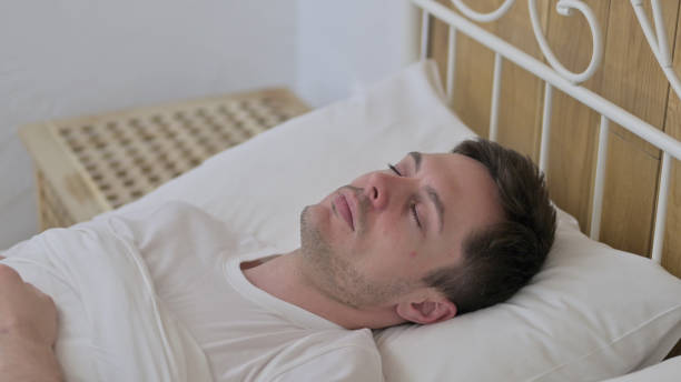 istock Attractive Young Man Sleeping in Bed Peacefully 1223378825