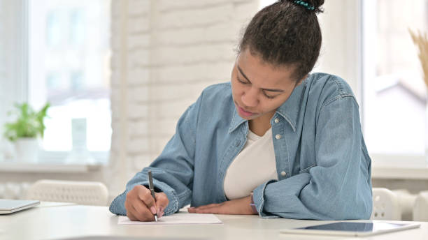 istock Young African Woman Writing at Work 1223379372