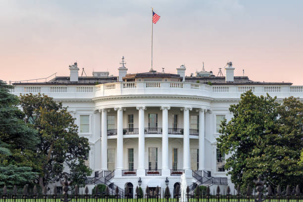 The White House The White House in Washington DC with american flag on sunset sky at summer sunset washington dc photos stock pictures, royalty-free photos & images