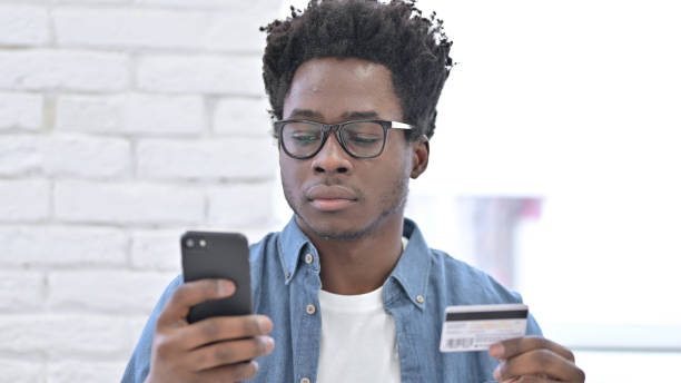 istock Young African Man using Credit Card on Smartphone 1223380364