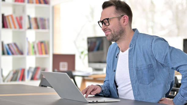 istock Young Man in Glasses having Back Pain in Office 1223380373