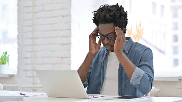 istock Young African Man having Headache on Laptop 1223380445