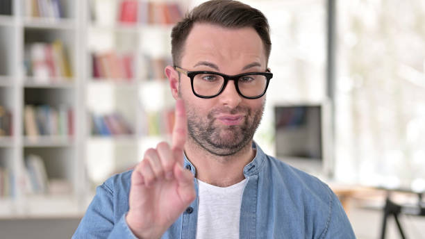 istock Young Man in Glasses saying No with Finger Sign 1223380582