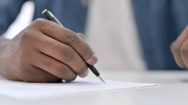 istock Close up Young African Man Hand writing Document 1223380775