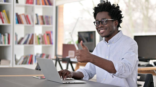 istock Thumbs Up by African Man Working on Laptop 1223380897