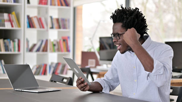 istock African Man Celebrating Success on Tablet, Winning 1223380937