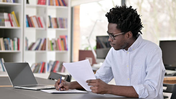 istock Paperwork by African Man in Office 1223380986