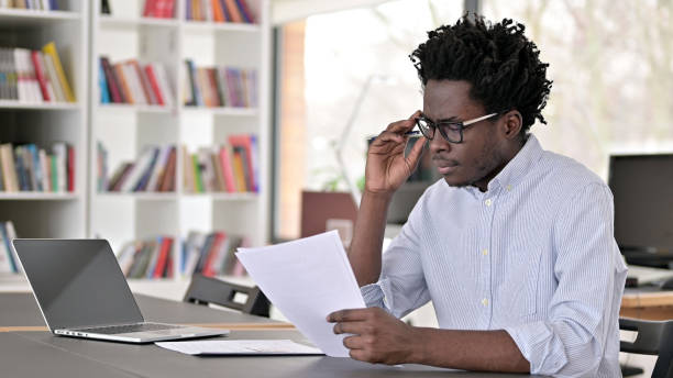 istock Focused African Man doing Paperwork in Office 1223380989