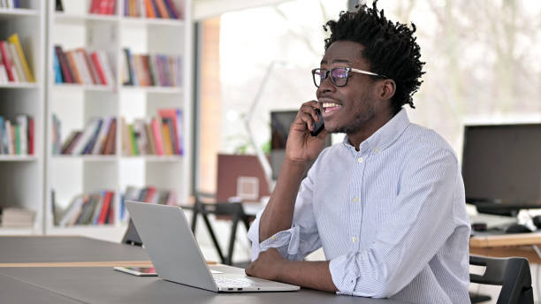 istock Happy African Man Talking on Phone at Work 1223381252