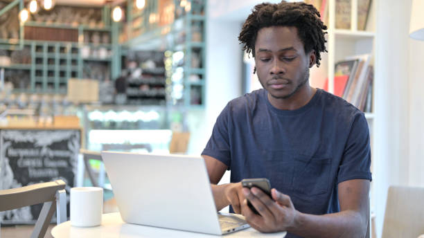 istock African Man using Smartphone and Laptop in Cafe 1223381535