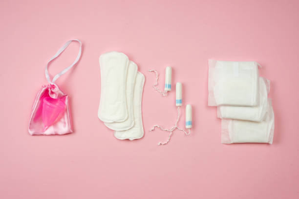 almofadas femininas, absorventes e copo menstrual isolados no fundo rosa. - tampon healthcare and medicine menstruation indoors - fotografias e filmes do acervo
