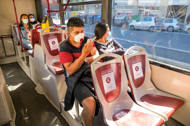 alguns passageiros com máscara médica dentro de um ônibus público em roma mantêm distanciamento social - southern europe public transportation international landmark local landmark - fotografias e filmes do acervo