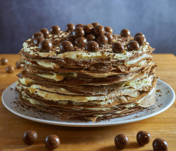 上と木製のテーブルと暗い背景にチョコレートボールとチョコレートクレープケーキ - baked brown cake circle ストックフォトと画像