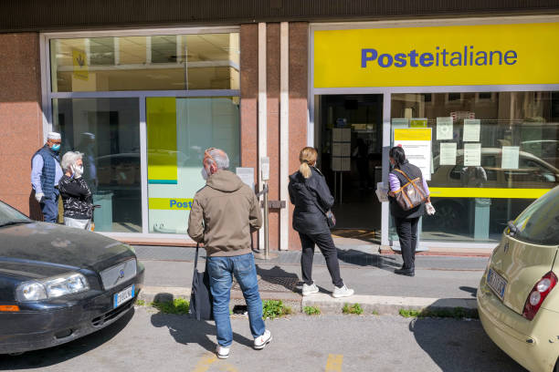 algunas personas protegidas por una máscara médica esperan en la cola en el norte de roma - oficina de correos fotografías e imágenes de stock