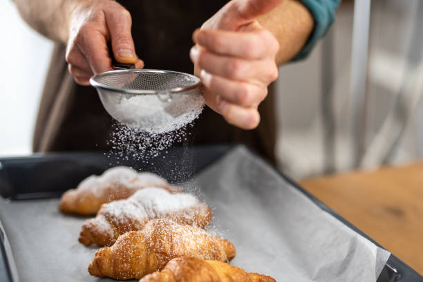 istock Chef sprinkling powdered sugar on croissants 1223383995